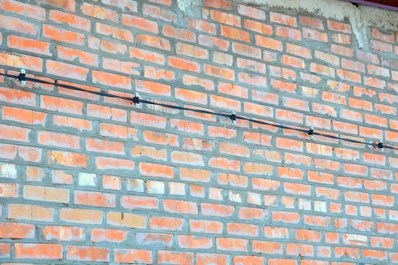 New brick wall and wiring harness on it. Installing wires. stock image New brick wall and wiring harness on it. Installing wires. stock image