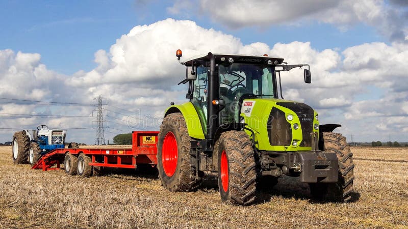 A Claas 630 tractor pulling a trailer to load vintage tractor stock photo