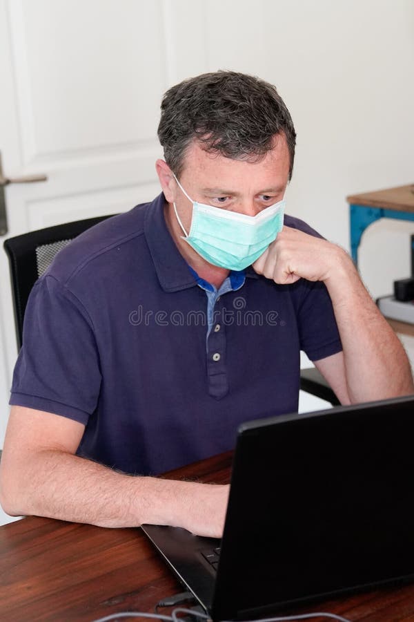 New coronavirus COVID-19 quarantine home office man freelancer working computer from house room royalty free stock image