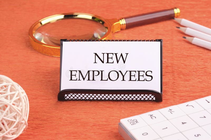 NEW EMPLOYEES word written on a white card on a black stand royalty free stock photo