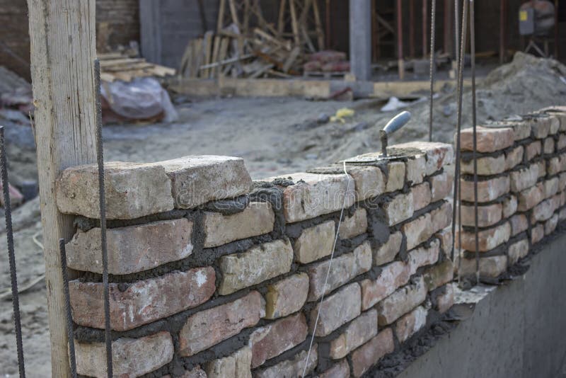 New foundation brick wall, building and construction concept. The foundations have been laid and the walls have been started.