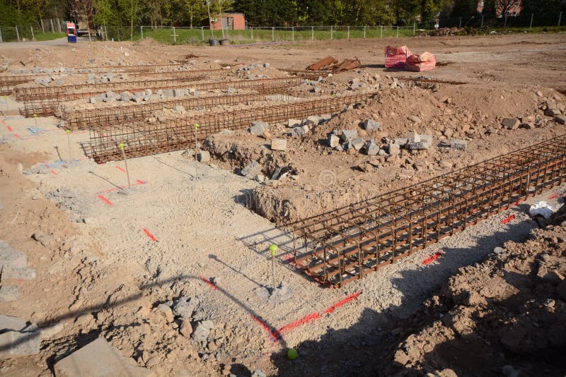 New house footings and groundwork for building construction. Groundwork and steel re-inforcement for concrete base on building construction site where new homes are being built showing construction methods.