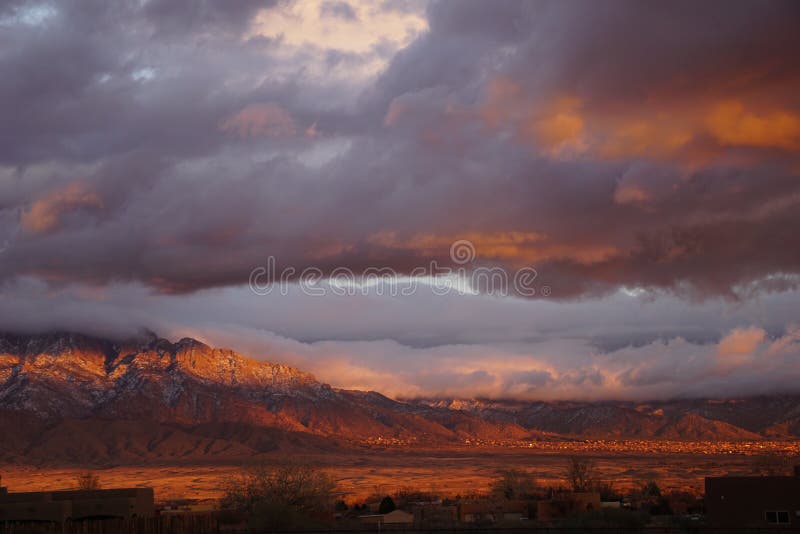 A New Mexico sunset with mountains and clouds.