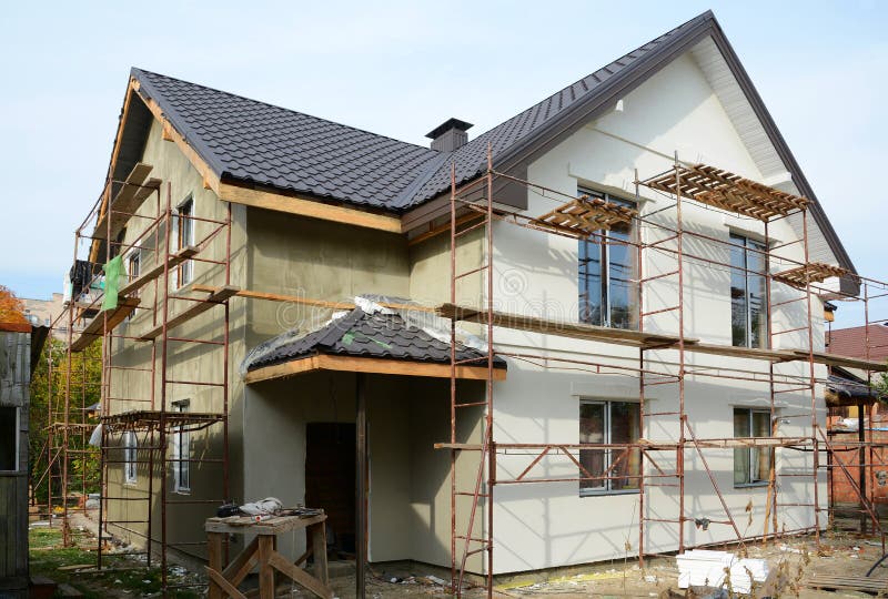 New modern house building home. Roof construction. Metal chimney. Insulated and plastered facade. Metal House roof.