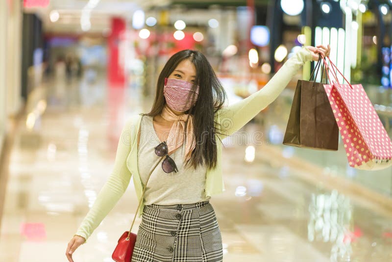 New normal habits - young attractive and happy Asian Chinese woman at shopping mall happy and excited enjoying sale in beauty royalty free stock photos New normal habits - young attractive and happy Asian Chinese woman at shopping mall happy and excited enjoying sale in beauty royalty free stock photos