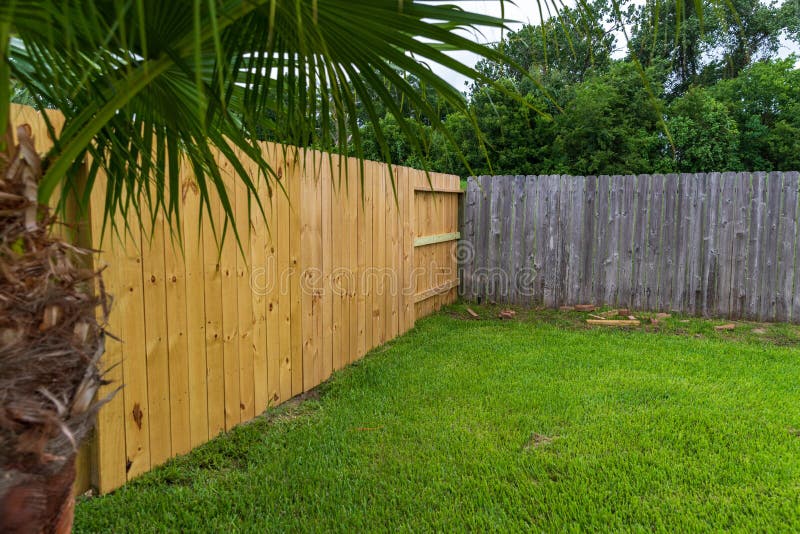 Wooden privacy fence, new and old in the same yard. New and Old privacy wooden fences in back yard royalty free stock photography