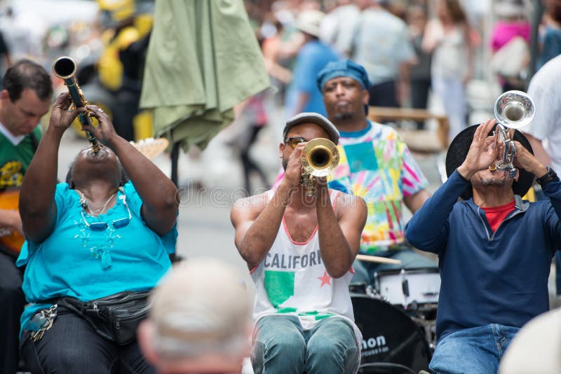 NEW ORLEANS - APRIL 13: In New Orleans, view of a jazz band plays jazz melodies in the street for donations from the tourists and locals passing by on April 13, 2014. NEW ORLEANS - APRIL 13: In New Orleans, view of a jazz band plays jazz melodies in the street for donations from the tourists and locals passing by on April 13, 2014