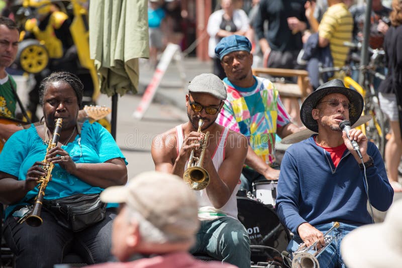 NEW ORLEANS - APRIL 13: In New Orleans, view of a jazz band plays jazz melodies in the street for donations from the tourists and locals passing by on April 13, 2014. NEW ORLEANS - APRIL 13: In New Orleans, view of a jazz band plays jazz melodies in the street for donations from the tourists and locals passing by on April 13, 2014