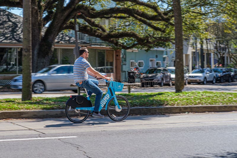 Man riding bicycle on city street in Mid City neighborhood of New Orleans, Louisiana, USA. Man riding bicycle on city street in Mid City neighborhood of New Orleans, Louisiana, USA