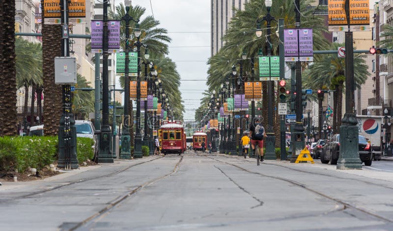 NEW ORLEANS - LUISIANA, EL 11 DE ABRIL DE 2016: Paisaje urbano de New Orleans con la tranvía y la gente Las bicicletas, los cabal fotografía de archivo NEW ORLEANS - LUISIANA, EL 11 DE ABRIL DE 2016: Paisaje urbano de New Orleans con la tranvía y la gente Las bicicletas, los cabal fotografía de archivo