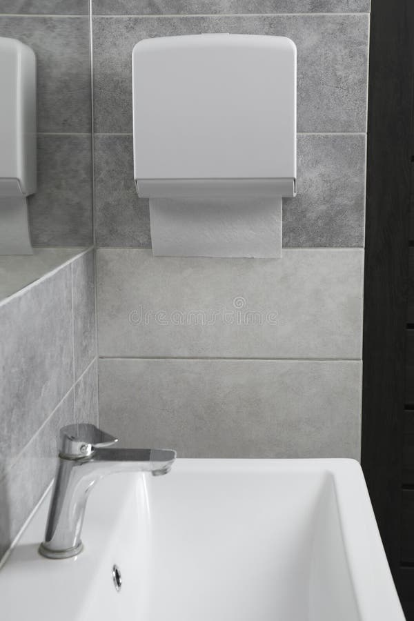 New Paper Towel Dispenser Hanging on Wall in Bathroom Stock Photo