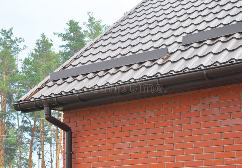 New roofing construction with rain gutter system, roof windows and roof protection from snow