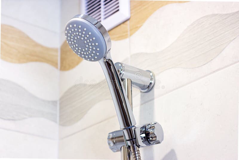 New Shiny Metal Shower Head on Ceramic Tile Wall Background in the