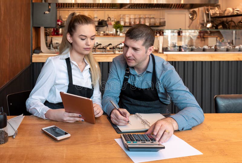 New small business owners counting revenue and expenses - Start-up entrepreneurs, woman and man, businessmen doing accounting royalty free stock photo New small business owners counting revenue and expenses - Start-up entrepreneurs, woman and man, businessmen doing accounting royalty free stock photo