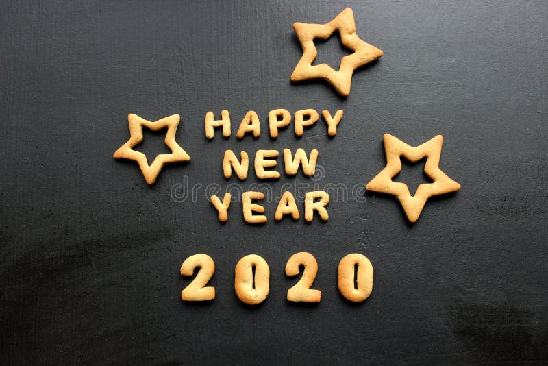 2020 new year background. Baked letters Happy New year and numbers 2020, stars, snowflakes on a black background