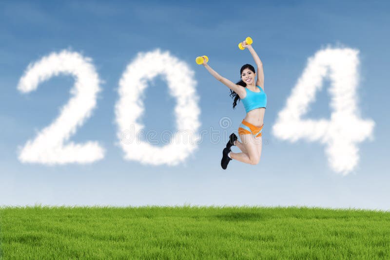 2014 New Year clouds and fitness woman jumping. Happy fitness woman jumping and 2014 New Year clouds outdoor royalty free stock images 2014 New Year clouds and fitness woman jumping. Happy fitness woman jumping and 2014 New Year clouds outdoor royalty free stock images