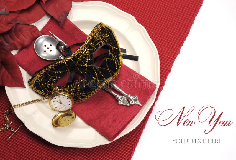 Bring in the New Year dining table place setting with masquerade mask, retro vintage pocket watch clock and fine china and antique silverware in a red, black and gold theme.