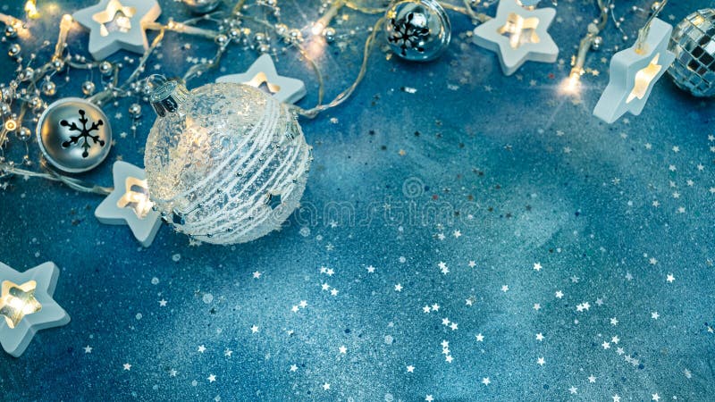 New year festive blue background with christmas tree decorations and glowing lights