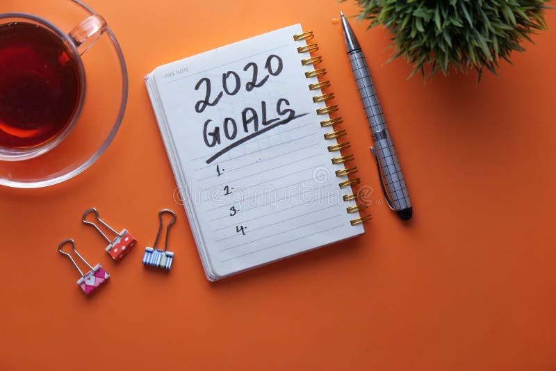 New year goals written on notepad on color background stock image