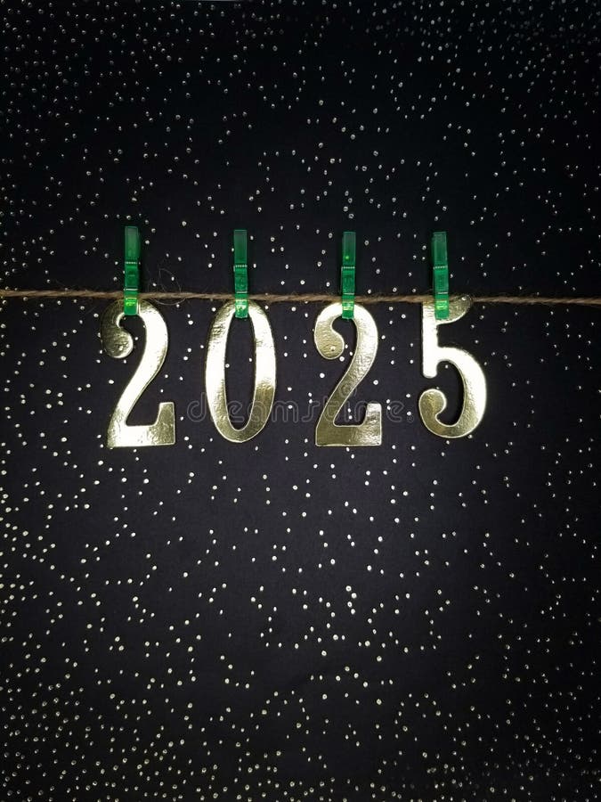 New Year 2025 numbers on green decorative clothespins on a rope starry sky on a black background stock images