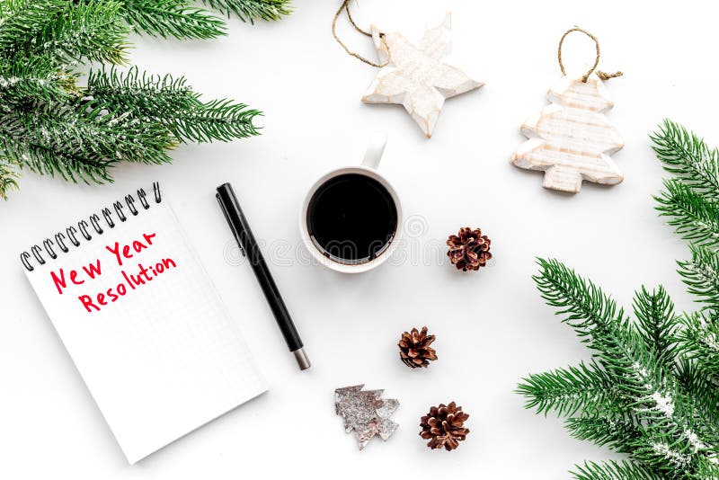 New year resolution. Notebook among christmas toy and spruce branch on white background top view stock image New year resolution. Notebook among christmas toy and spruce branch on white background top view stock image