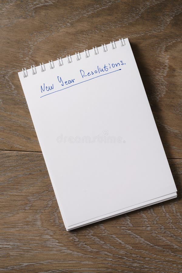 New Year Resolutions Tempate with Notepad on Wood Table Stock Image