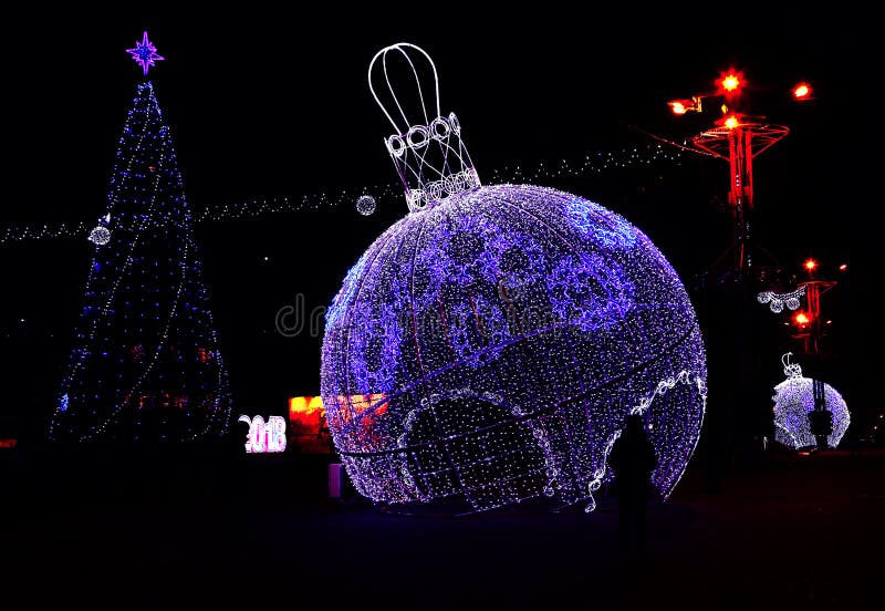 Blu incandescente luci nelle strade del Nuovo Anno, sullo sfondo di un albero di Natale decorato.