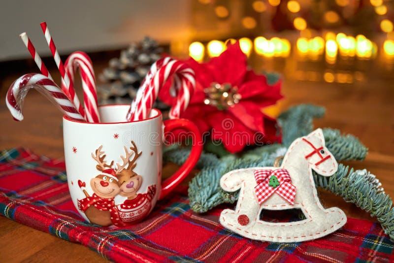 New Year`s Cup of hot drink in front of the Christmas tree on a red tablecloth stands near the New Year`s decorations