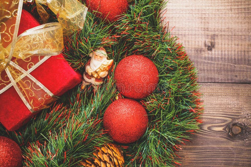 New Year`s decor and festive toys on a wooden table with a red string box with a gift Santa Claus.Happy New Year stock photography New Year`s decor and festive toys on a wooden table with a red string box with a gift Santa Claus.Happy New Year stock photography