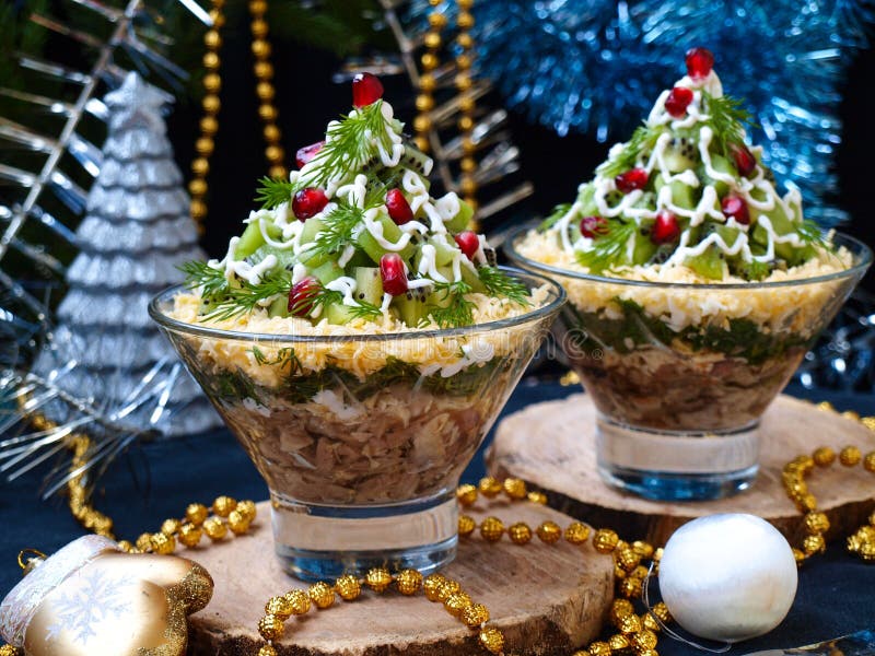 New Year`s Eve Salad in bowls in the form of a Christmas tree, decorated with pomegranate seeds