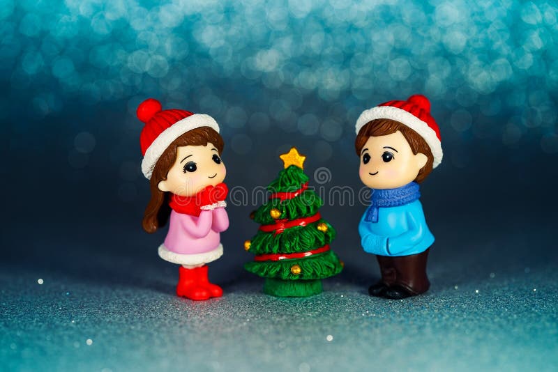 Figurines of children at the Christmas tree on a blue background. Holiday Toys royalty free stock photo