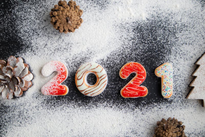 New Years concept - gingerbread cookies with 2021 number-shaped icing, floured to simulate snow. Banner, poster, postcard