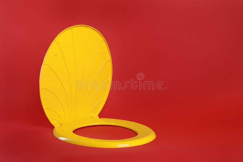 New Yellow Plastic Toilet Seat on Red Background, Space for Text Stock