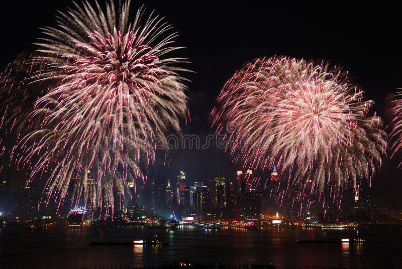 New York City Manhattan July 4th Independence day fireworks show with skyline over Hudson River viewed from New Jersey. New York City Manhattan July 4th Independence day fireworks show with skyline over Hudson River viewed from New Jersey