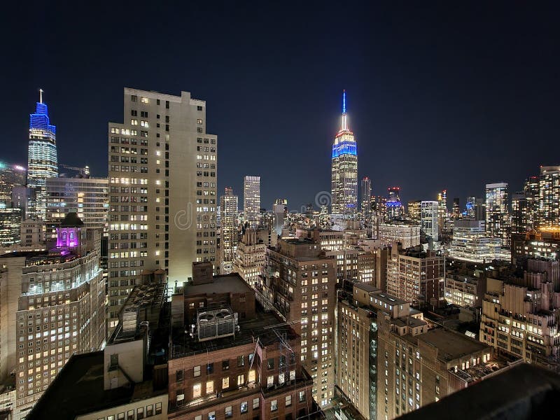 New York city skyscrapers at night with empire state view building  seen from a rooftop bar