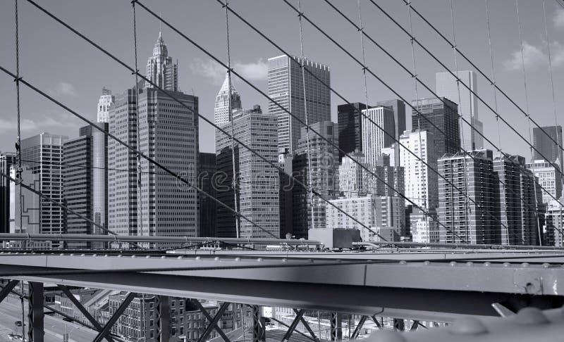 New York City skyscrapers seen through the wires of the Brooklyn Bridge.