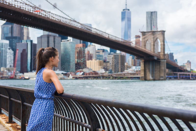 New York city urban tourist woman looking at Brooklyn bridge and skyline