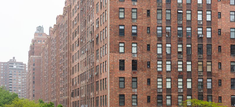 New York, Manhattan Chelsea area. Brick wall facade skyscrapers against cloudy sky background