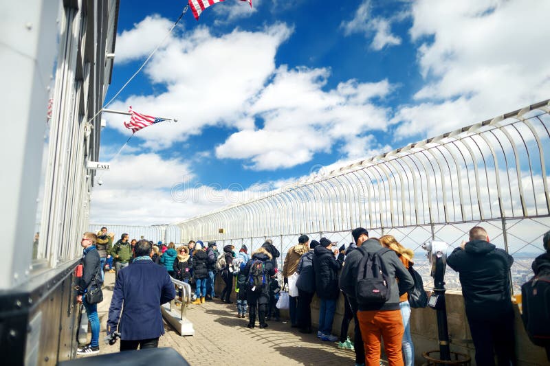 NEW YORK - MARCH 16, 2015: Tourists enjoying breathtaking views from the observation deck of Empire State Building. stock images NEW YORK - MARCH 16, 2015: Tourists enjoying breathtaking views from the observation deck of Empire State Building. stock images