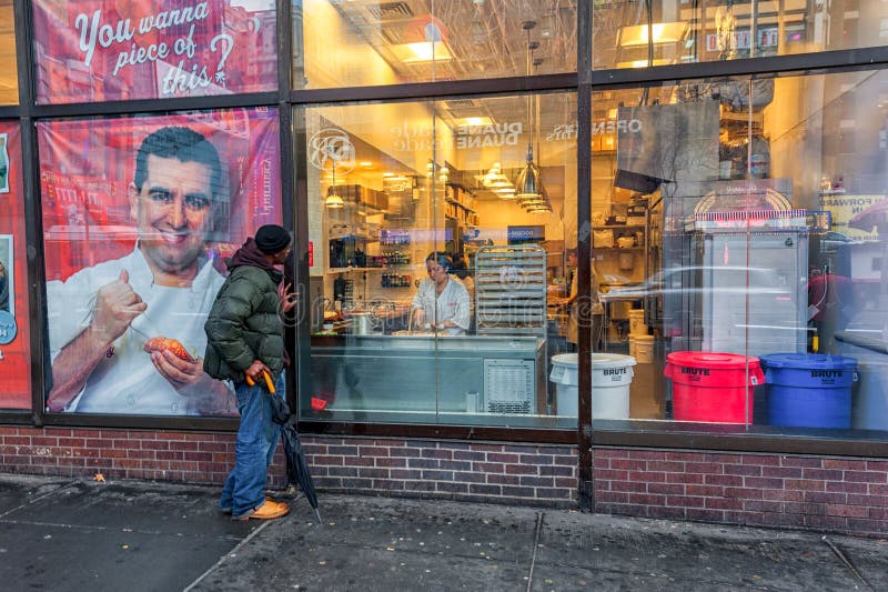 NEW YORK NEW YORK - JANUARI 10, 2014: Unknow person som ser till och med fönstret till mattillverkaren Restaurang arkivbild NEW YORK NEW YORK - JANUARI 10, 2014: Unknow person som ser till och med fönstret till mattillverkaren Restaurang arkivbild