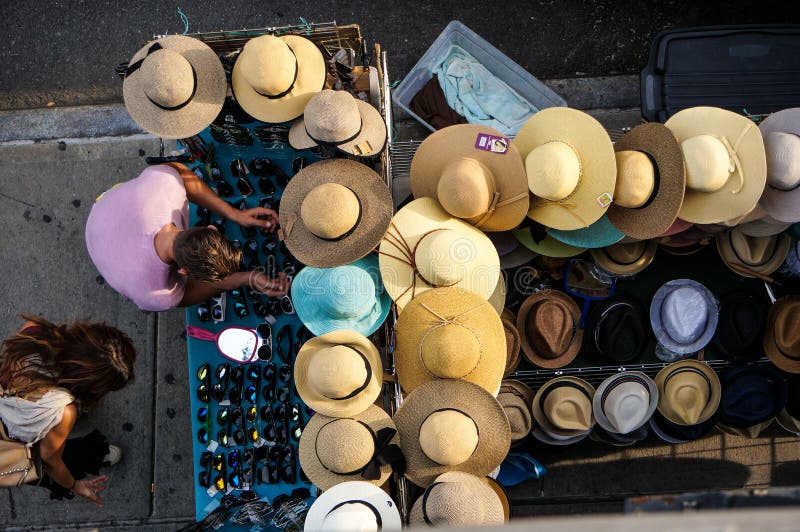 Man and woman choosing glasses for themselves near the table with hats and glasses on the street. Summer. Daylight. royalty free stock images Man and woman choosing glasses for themselves near the table with hats and glasses on the street. Summer. Daylight. royalty free stock images