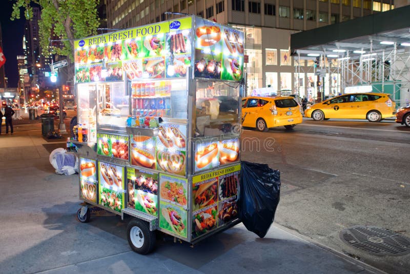 NEW YORK CITY - OCTOBER 23, 2015: Street food vendor at night. Vendors are usually distributed in Midtown. NEW YORK CITY - OCTOBER 23, 2015: Street food vendor at night. Vendors are usually distributed in Midtown.