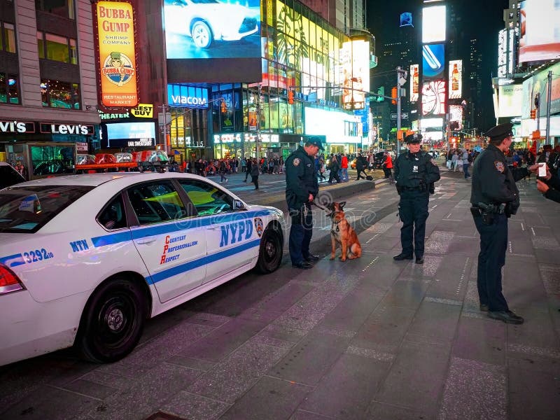 NEW YORK TIMES-QUADRAT, APR, 24, 2015: Times Square-Polizeibeamtemänner und schöne Polizistin, Polizeiwagen und Hund unter Leuten stockfotografie NEW YORK TIMES-QUADRAT, APR, 24, 2015: Times Square-Polizeibeamtemänner und schöne Polizistin, Polizeiwagen und Hund unter Leuten stockfotografie