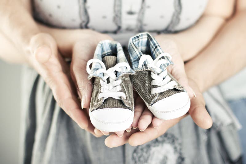 Newborn baby booties in parents hands stock photos