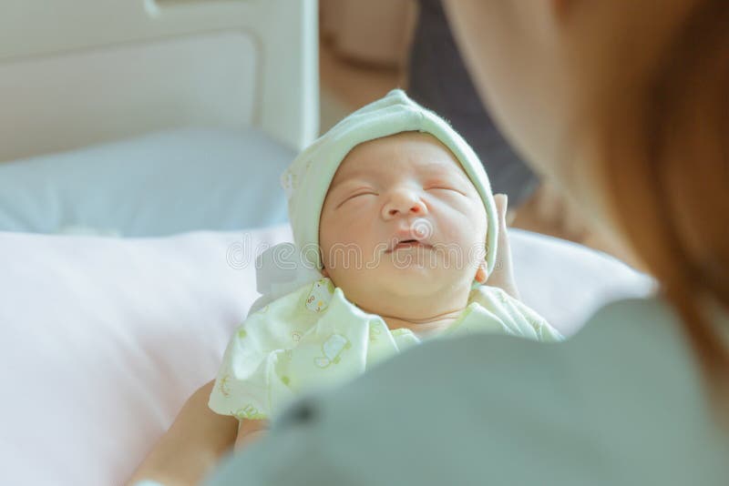 Newborn Baby Boy Sleeping In Asian Mother Hand At Hospital Stock Photo