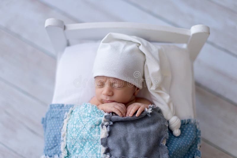 Newborn Baby Boy Sleeping on a Tiny Bed stock image Newborn Baby Boy Sleeping on a Tiny Bed stock image