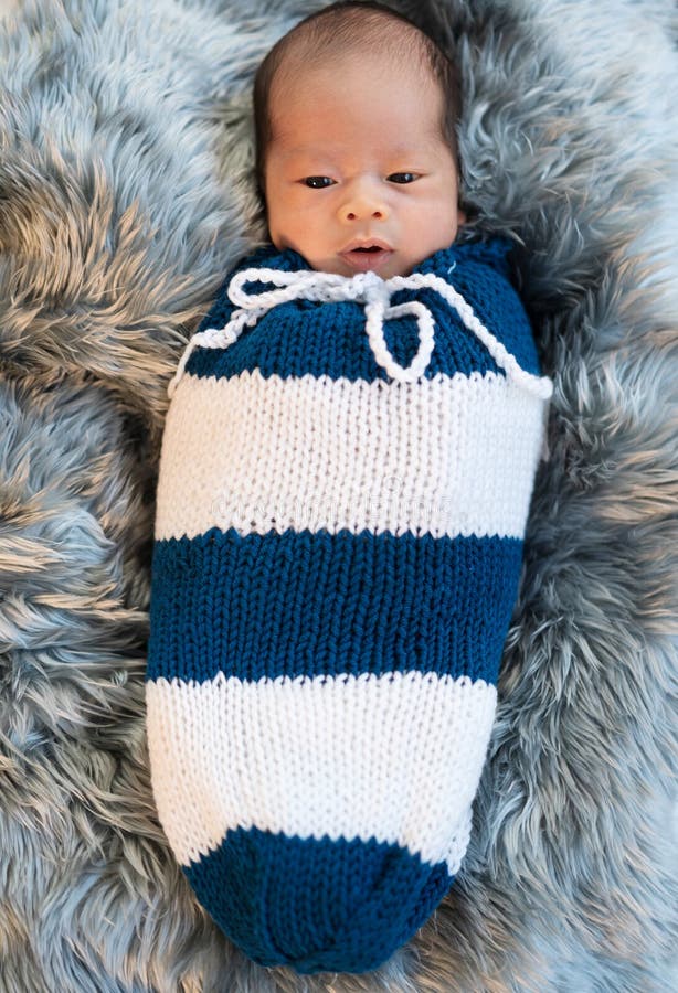 Newborn Baby Boy Swaddled In A Knit Wrap On Fur Bed Stock Photo Image