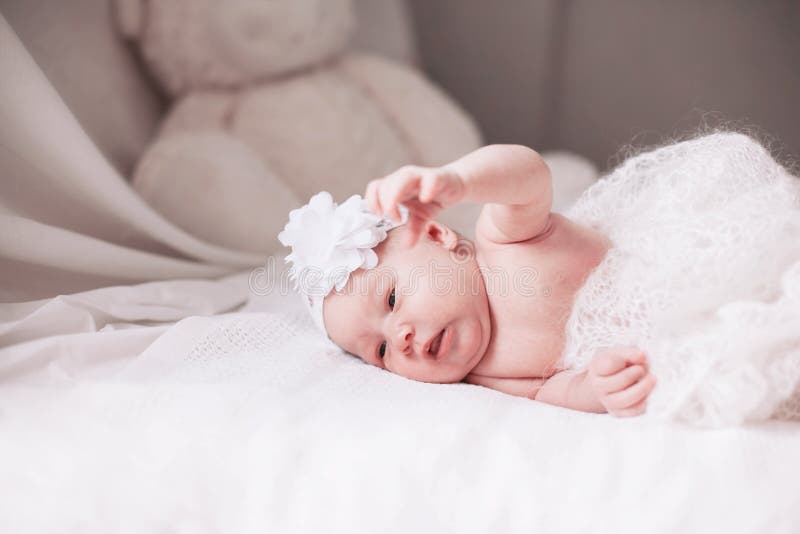 Newborn baby girl in a beautiful bonnet lying on a blanket. stock photos Newborn baby girl in a beautiful bonnet lying on a blanket. stock photos