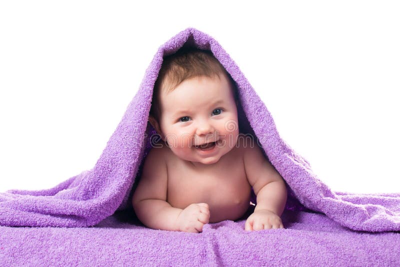 Newborn baby lying down and smiling in a purple towel