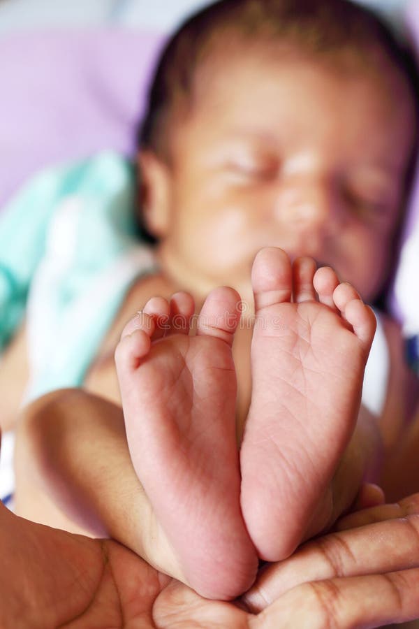 Newborn Baby`s feet.Mother holding newborn baby legs